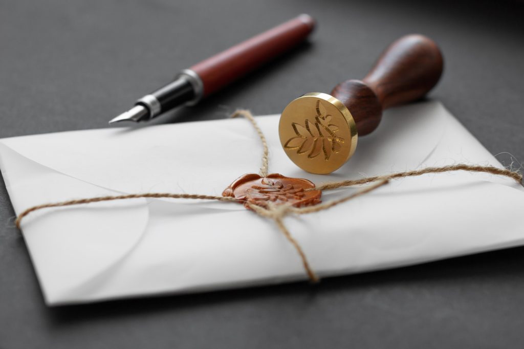 Notary public wax stamper. White envelope with brown wax seal, golden stamp. Responsive design