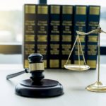 Gavel hammer, justice scale, and law textbook on table in lawyer office for providing legal consult