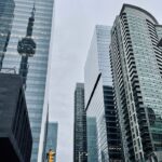 Low angle shot of skyscrapers with CN Tower reflection in Toronto's financial district.