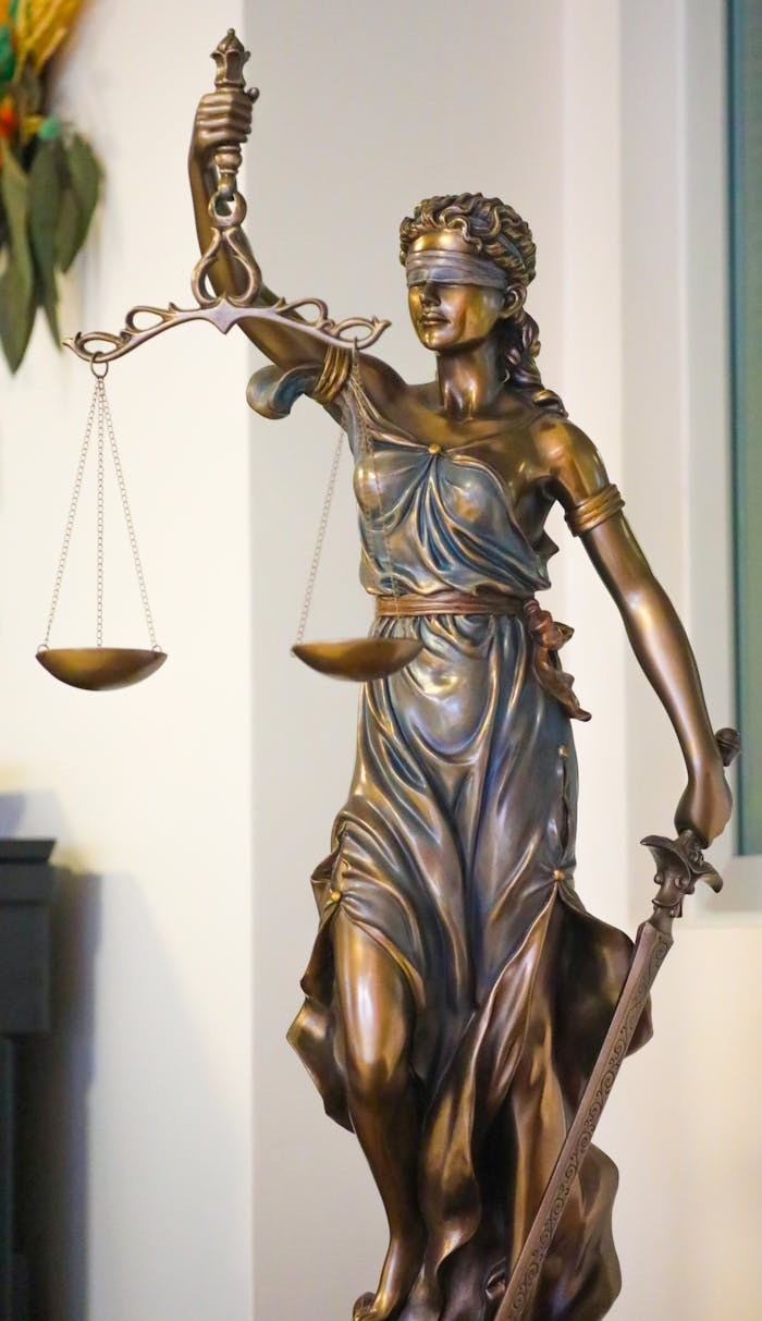 services-01 Bronze Lady Justice statue with scales and sword, symbolizing law and fairness, displayed indoors in İstanbul.