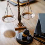 High angle lawyers desk with decorative judgement scales and gavel in modern law firm