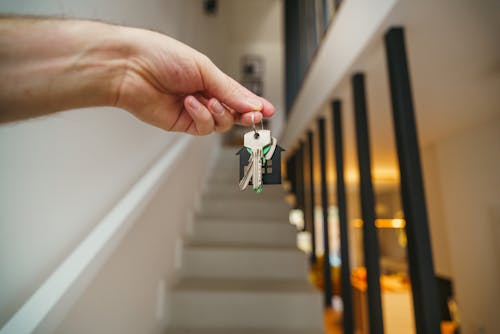 How to Legally Handle a Tenant’s Breach of Lease Agreement Free A hand holding house keys in a modern interior, symbolizing new home ownership or real estate investment. Stock Photo