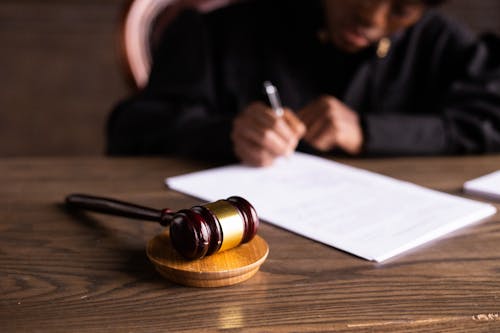 The Eviction Process Explained: A Guide for Landlords and Tenants Free Judge signing documents at desk with focus on gavel, representing law and justice. Stock Photo